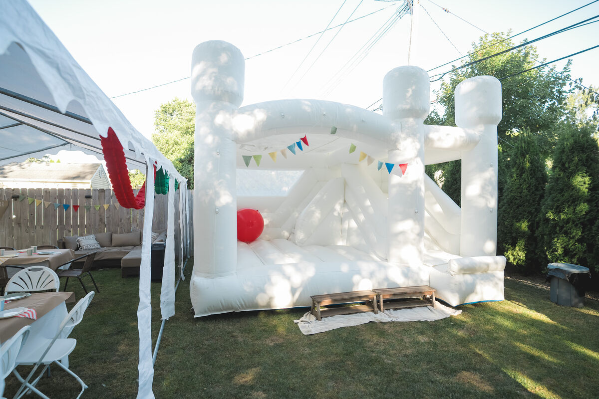 White castle bounce house with colorful pennant banners in backyard